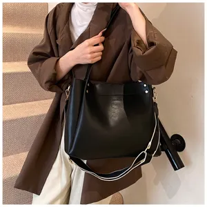 Detail view of the black leather shoulder bag with wide strap, stylish everyday carry.