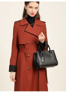 Detailed view of women's black litchi pattern structured tote handbag paired with stylish trench coat.