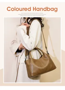 Detailed shot of vintage brown handbag with adjustable wide strap worn by model in coat.