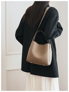 Soft leather bucket bag detail showing fine texture, shoulder strap and bottom feet.