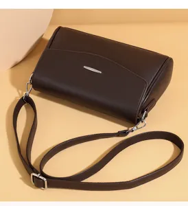 Detailed view of the dark brown leather shoulder bag, highlighting the strap and buckle.
