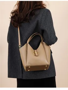 Detail shot of women's genuine leather bucket bag with litchi grain and metal clasp.