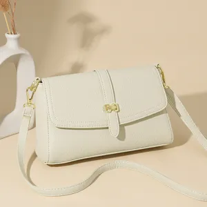 Minimalist women's small square shoulder crossbody bag in cream white with gold hardware.