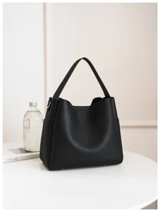Minimalist black soft leather bucket bag detail showing chic handle and stylish side pocket design.