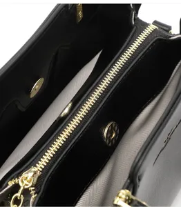 Détails intérieurs du sac à main noir avec fermeture éclair dorée et compartiments pratiques.