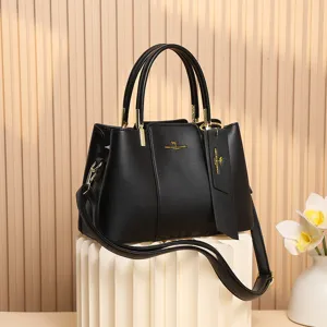 Élégant sac à main noir texturé en cuir synthétique pour femme avec poignées et détails dorés.