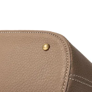 Nahaufnahme Detail eines Echtleder Beutel Tasche Bodens mit Kontrastnaht und Metallniete.