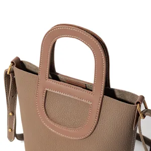 Nahaufnahme eines Echtleder-Eimer-Tasche mit markantem H-förmigen Griffdesign.