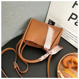 Brown PU leather bucket bag detail with pink heart silk scarf handle wrap and shoulder strap.