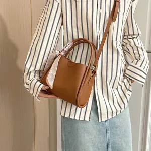 Detail view of stylish brown PU leather shoulder bag with chic handle scarf accessory.