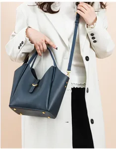 Detail of women genuine leather bucket shoulder bag with litchi pattern and metal hardware.