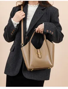Detail view of women's genuine leather bucket bag with top handle and shoulder strap.