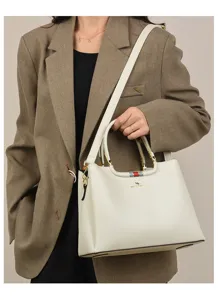 Elegant white leather tote bag for women with shoulder strap and stylish stripe detail design.