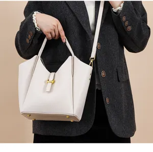 Genuine leather bucket bag with top handle and strap, stylish litchi pattern design for women.