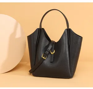 Detail shot of the black leather bucket bag showcasing exquisite litchi texture and hardware.