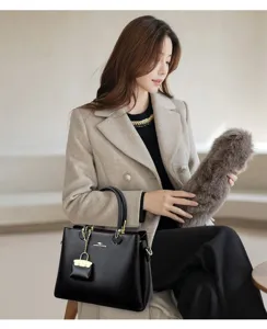 Elegant black leather handbag with gold hardware and stylish charm for women daily wear.