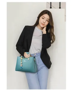 Sac à main élégant pour femme avec poignée en métal et charm, stylé et très pratique.