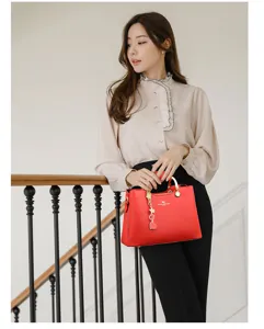 Élégant sac à main en cuir rouge pour femme, grand sac bandoulière élégant avec finitions.