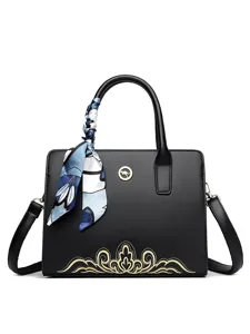 Elegant black leather handbag with chic golden embroidery and blue silk scarf, stylish women crossbody bag.
