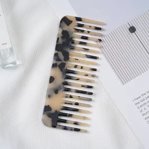 Detailed view of the acetate hair comb featuring a stylish marble pattern and wide teeth.