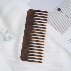 Tortoiseshell wide tooth acetate hair comb detail shot showing texture and smooth polished finish.