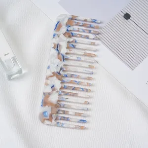 Acetate hair comb detail shot showcasing the elegant marble pattern and wide tooth design.
