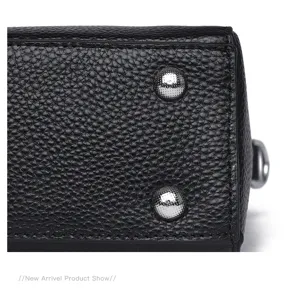 Detail shot showing black genuine cowhide handbag bottom texture with silver metal feet.