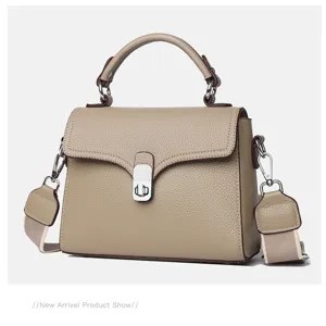 Detailed view of genuine leather top-handle crossbody bag with metal lock and wide strap.