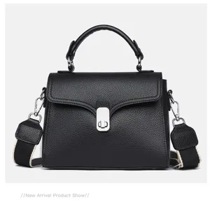 Black leather top handle bag detail, textured cowhide, flap closure with silver lock.