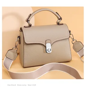 Detail view of genuine leather women handbag, top handle crossbody bag with wide strap texture.