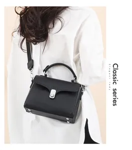 Close-up detail of the elegant black leather crossbody bag featuring a secure metal lock closure.