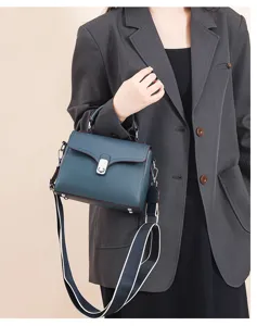 Leather handbag detail view, women casual crossbody shoulder bag with wide strap and lock.