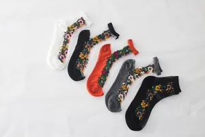 Transparente Netzsocken Detail mit bunter vintage Blumenstickerei und feiner Mesh-Struktur.