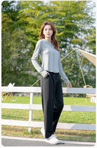 Outdoor detail showcase of a grey sun protection jacket and black pants for summer.