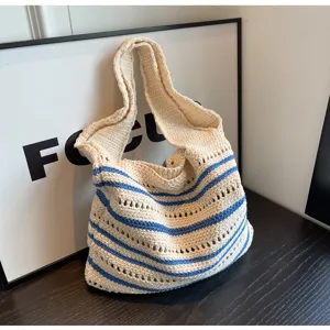 Detailed view of handmade striped knitted shoulder bag, casual woven textured fabric.