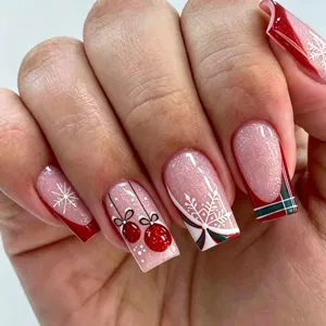 Close-up detail of Christmas press-on nails featuring glitter, snowflakes and plaid patterns.