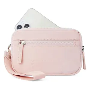 Close-up detail of the pink quilted mini wrist bag showing front zipper pocket and strap.