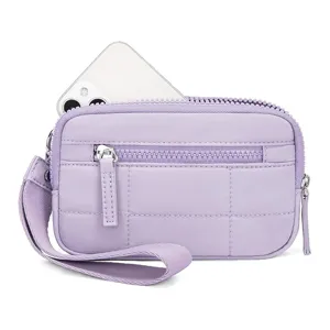 Detailed view of the purple quilted wristlet pouch featuring front zipper pocket and strap.