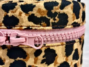Detailansicht der Kosmetiktasche mit Leopardenmuster und einem süßen rosa Reißverschluss.