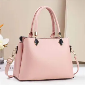 Close-up detail of the elegant pink leather handbag with refined gold hardware and sturdy handles.