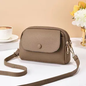Vue détaillée du sac bandoulière taupe polyvalent avec design à rabat et fermetures éclair.