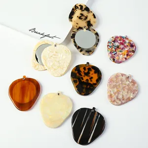 Portable strawberry shaped acetate makeup mirror detail view showcasing colorful variants and swivel design.