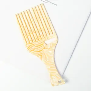 Gros plan sur les détails du peigne en acétate marbré, design élégant à dents larges pour coiffer.