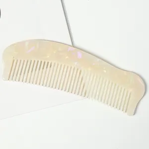 Vue detail d'un peigne à cheveux fin en acétate effet marbré nacré, design élégant et chic.