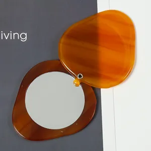 Portable mini swivel-cover round makeup mirror with strawberry acetate shell amber finish.