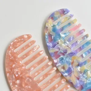 Detail view of marble pattern acetate wide-tooth hair comb, anti-static daily hair styling tool.