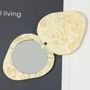 Close-up detail of the portable rotating makeup mirror with elegant acetate resin case.
