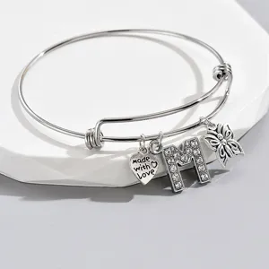 Adjustable silver tone charm bracelet featuring letter M, butterfly and heart pendants.