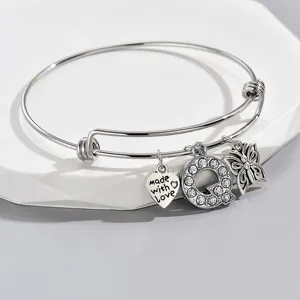 Adjustable silver wire bangle bracelet with heart, rhinestone letter Q, and butterfly charms.