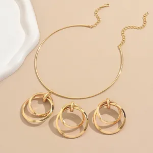 Detailansicht der goldenen ineinandergreifenden Mehrring-Choker-Halskette mit passenden Ohrringen.